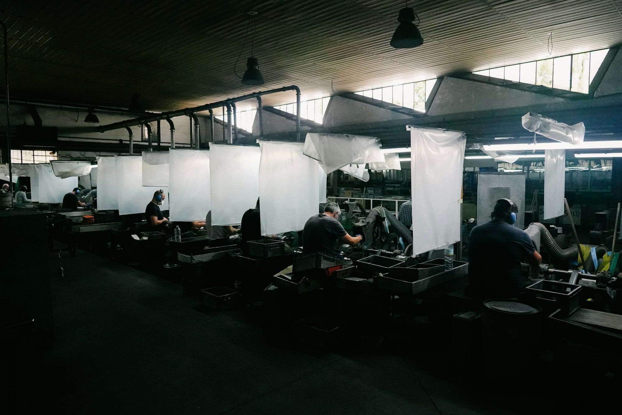 Werkshalle mit mehreren Arbeitsplätzen und Beschäftigten an Fertigungsmaschinen, als Sinnbild für den deutschen Maschinenexport nach Spanien und Lateinamerika