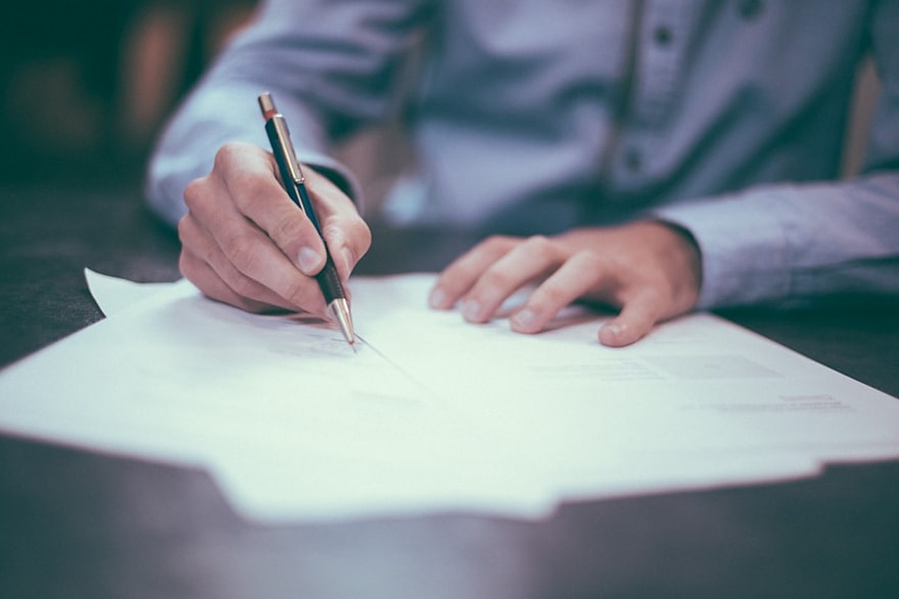 Business professional signing certified corporate documents