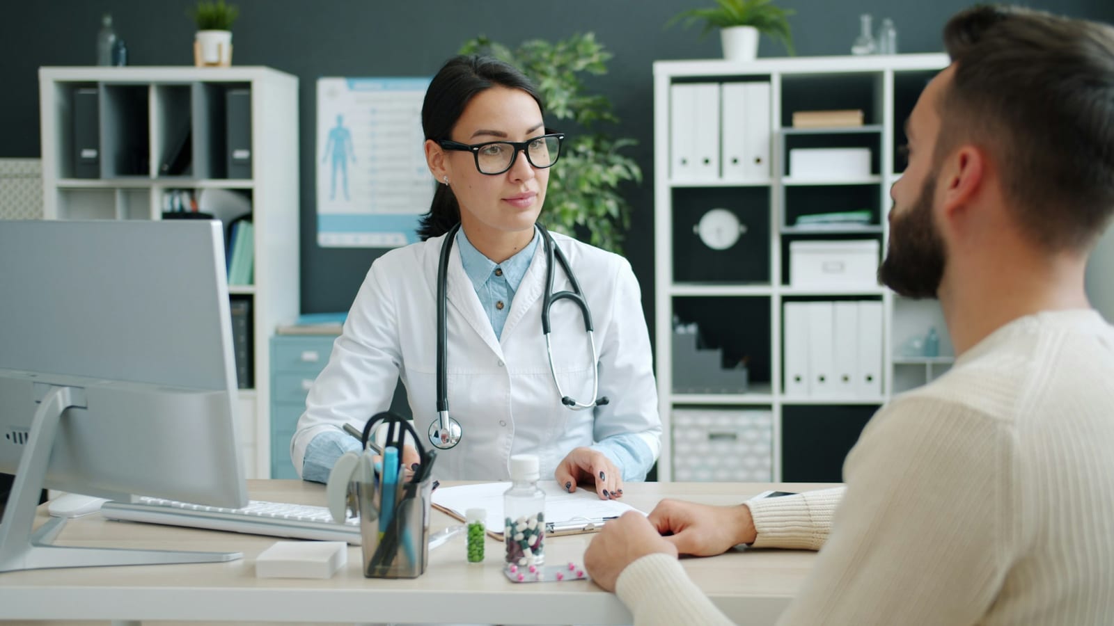Doctor consulting with a patient through a professional medical interpreter in a hospital exam room