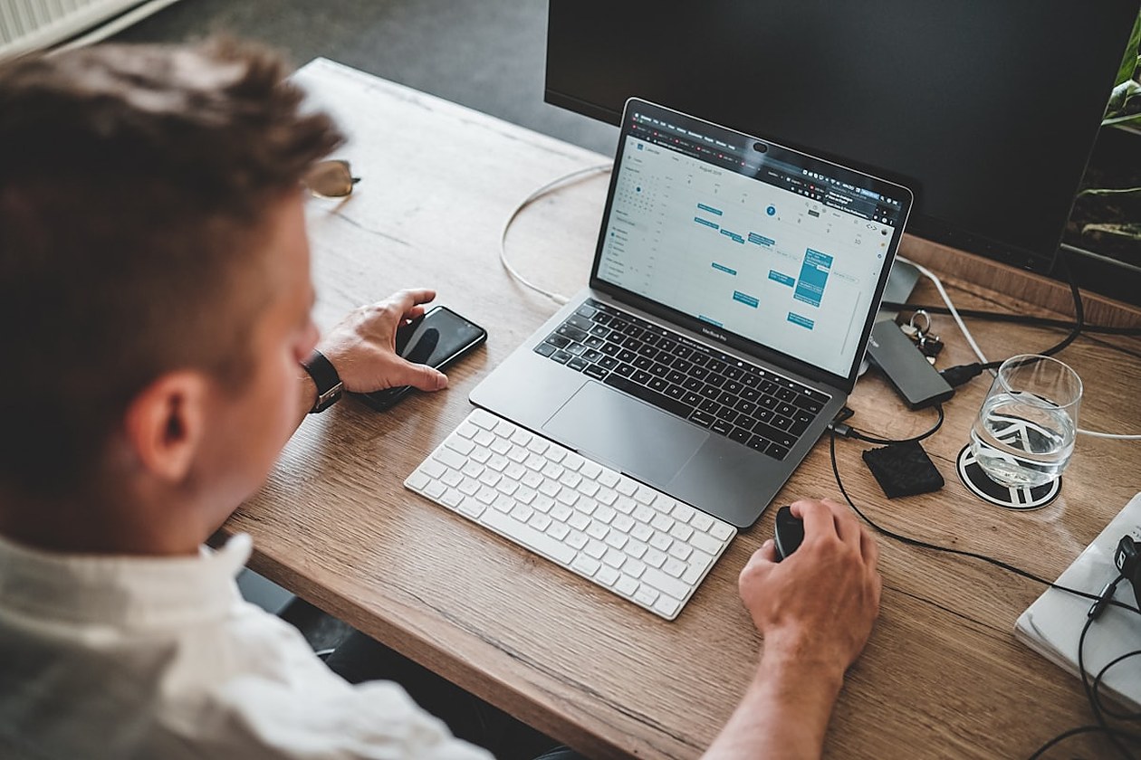 Professionnel consultant un calendrier de planification sur un ordinateur portable, en phase de préparation d'une mission