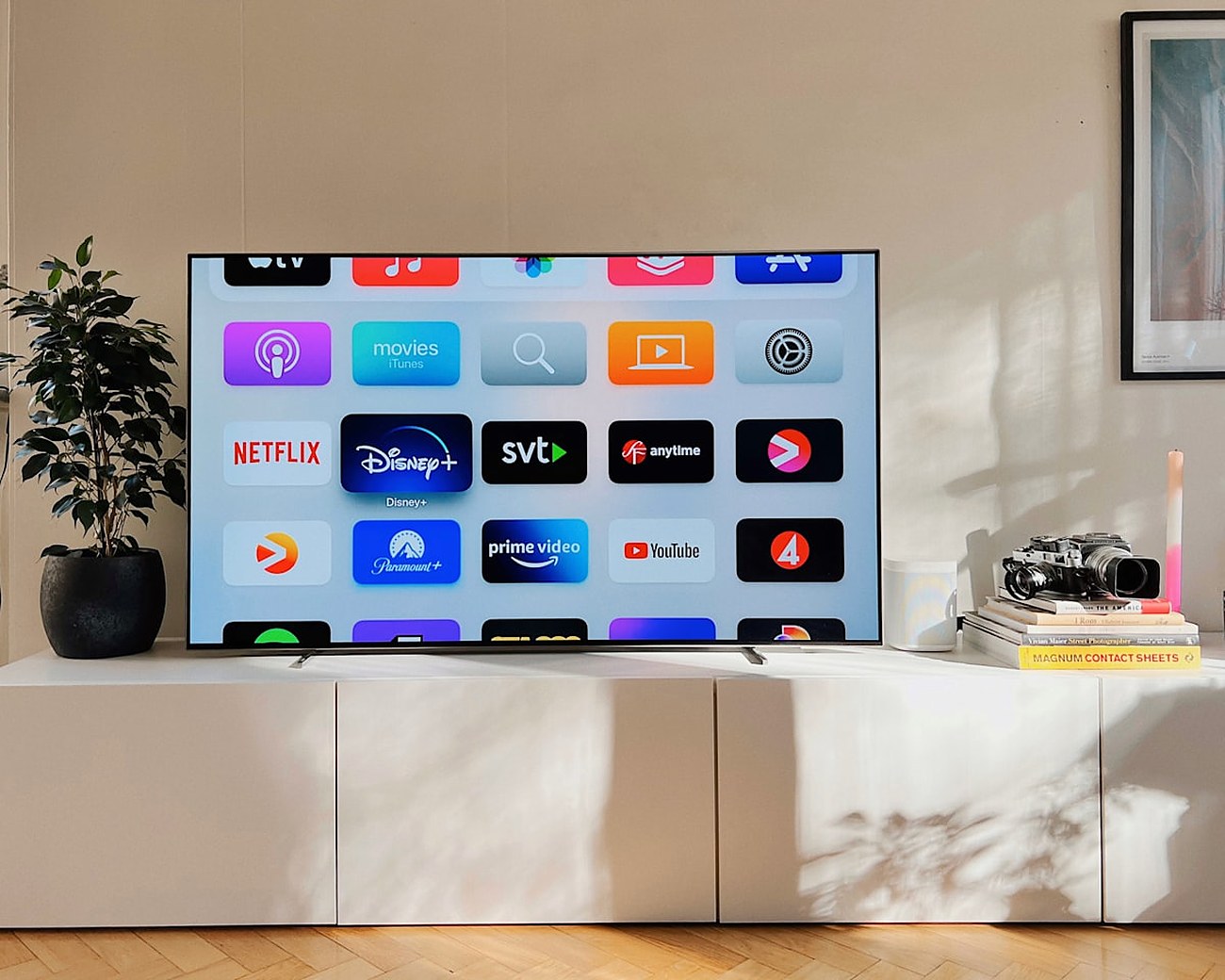 Televisor de saló amb una graella d'aplicacions de streaming (Netflix, Disney+, Prime Video) en una habitació lluminosa amb plantes