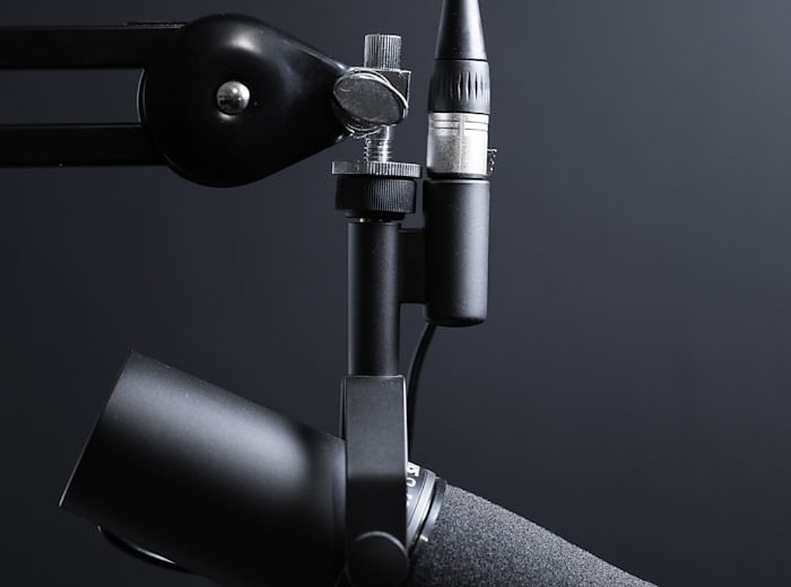 Microphone professionnel monté sur un bras articulé dans un studio d'enregistrement, symbole du travail de doublage et d'adaptation de dialogues
